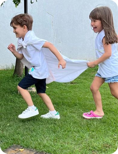 Crianças brincando com uma capa no gramado, Escola Infantil em Santo André