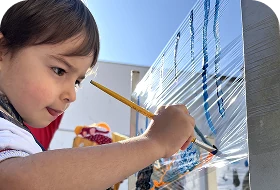 Criança pintando um painel com pincel, Escola Infantil em Santo André