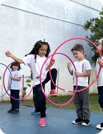 Crianças brincando com bambolês no pátio, Escola Infantil em Santo André